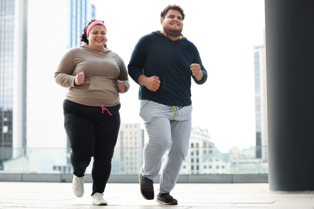 Overweight couple running together outdoors