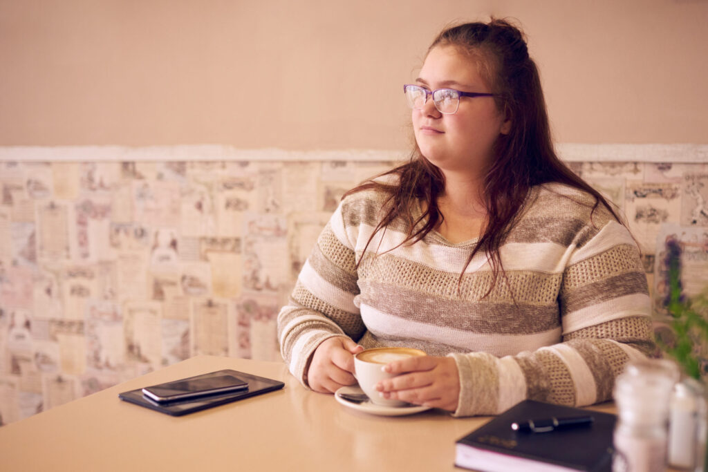 overweight-woman-holding-a-cup-of-coffee-in-a-cafe