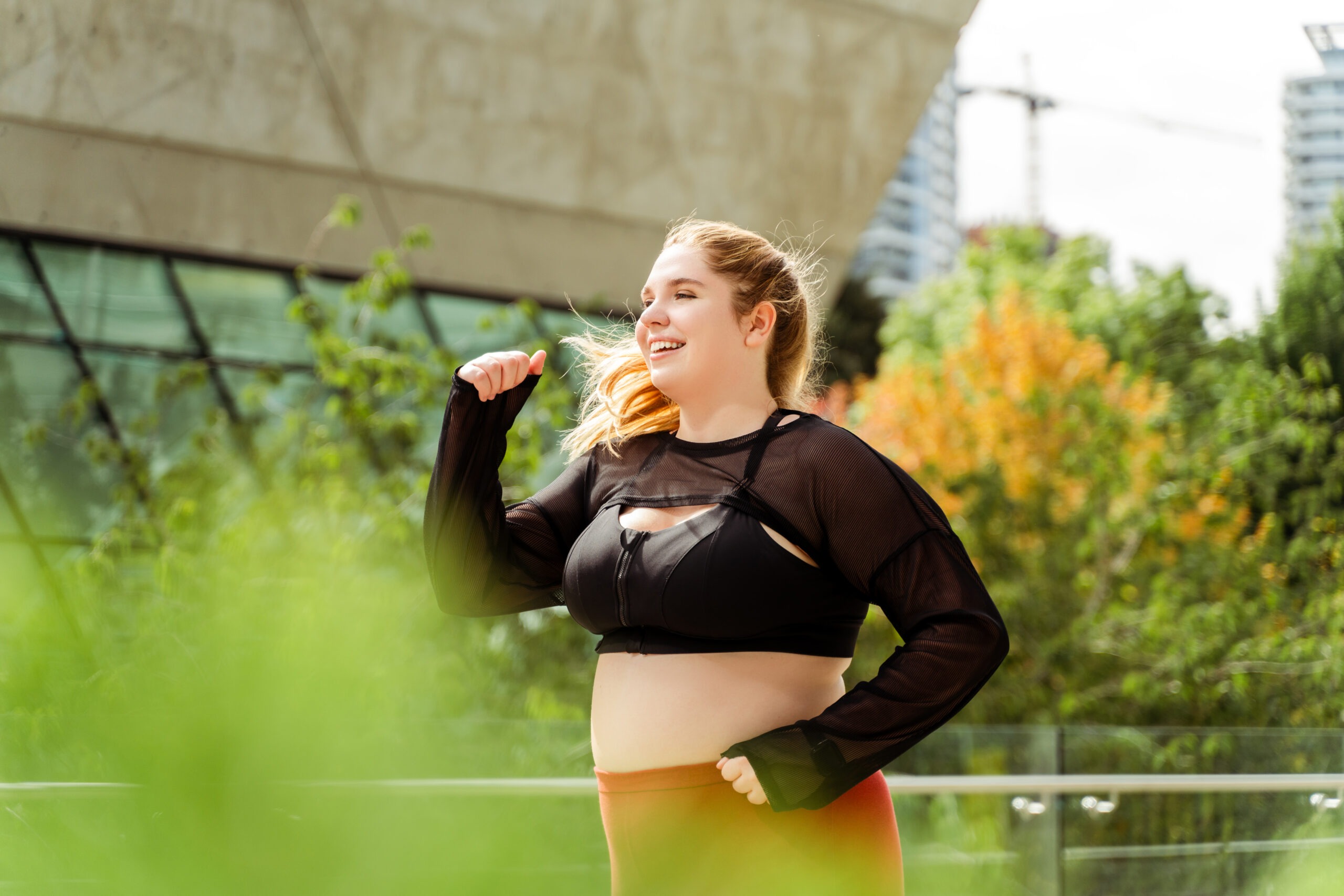 Happy plus size woman jogging in the city. Sport, motivation, training