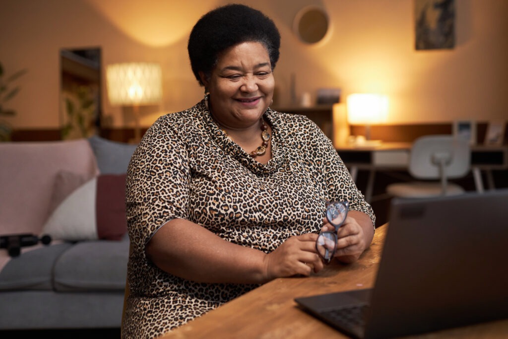 Portrait Black woman smiling happily talking via video chat with friends